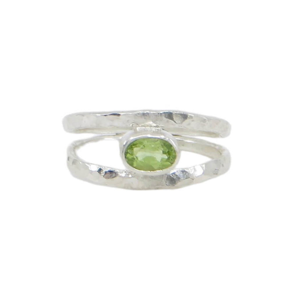 A faceted oval peridot is set east-west in a tube setting hugged on either side by hammered sterling silver bands. The bands taper down towards the center at bottom of ring. Shimmery, airy, fine, contemporary. US size 5.75 could be sized up to size 6.