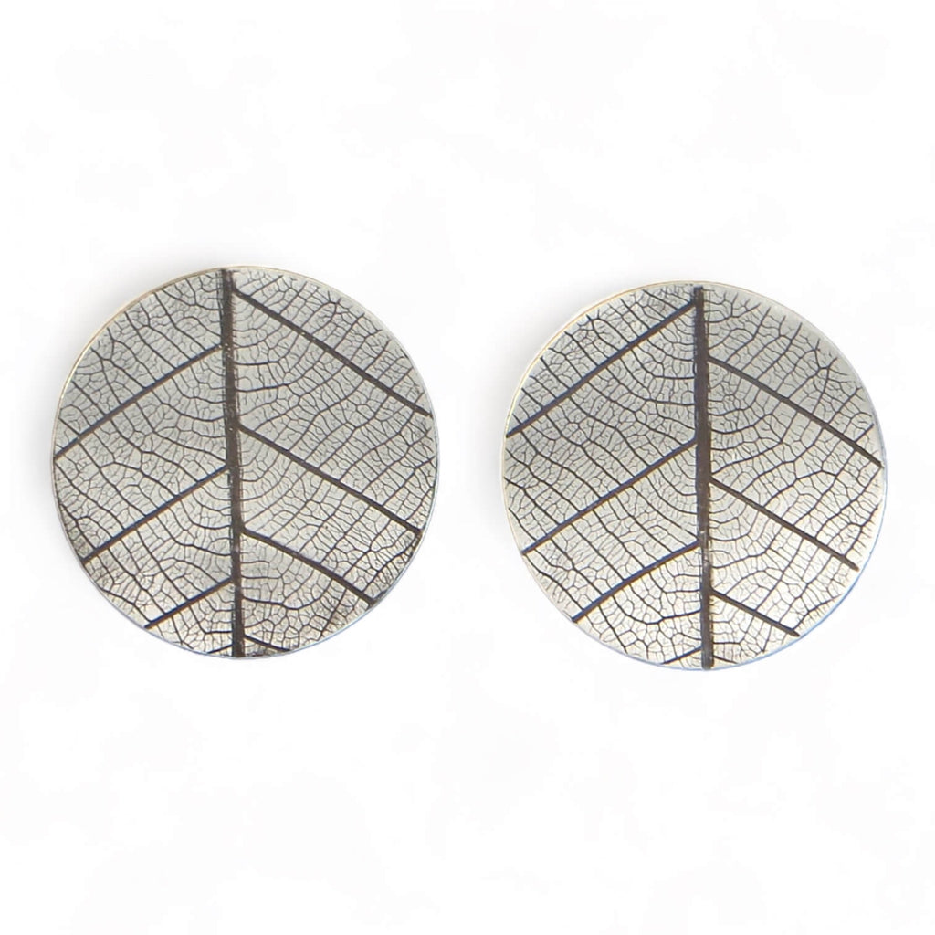 Leaves!  These round silver post earrings have indented impressions of a real leaf.  No other pair will have this exact leaf design. A black patina in the recesses highlight the delicate veins which happen to resemble a peace sign--with some addition lines!  These are curved ever so slightly that they hand perfectly from the ear lobe.  Sterling Silver 1" diameter Peace!