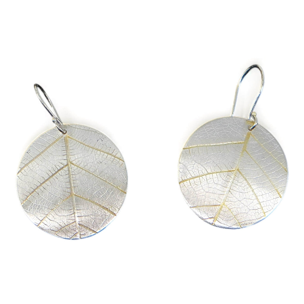 Hint of Gold!  These round silver dangle earrings have indented impressions of a real leaf.  No other pair will have this exact leaf design. 18k gold in the recesses highlight the prominent veins which happen to resemble a peace sign--with some addition lines!  These are curved ever so slightly that they hand perfectly from the ear.  Sterling Silver 18k Gold 1" diameter disc.  ﻿Peace!