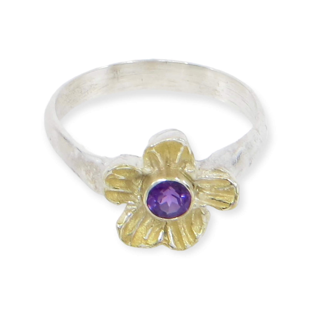 A dimensional textured flower has a center tube set faceted amethyst. A sterling silver ring band golds the sterling flower embellished with 18k gold. Royal colors on a chunky cool flower ring. US Size 6