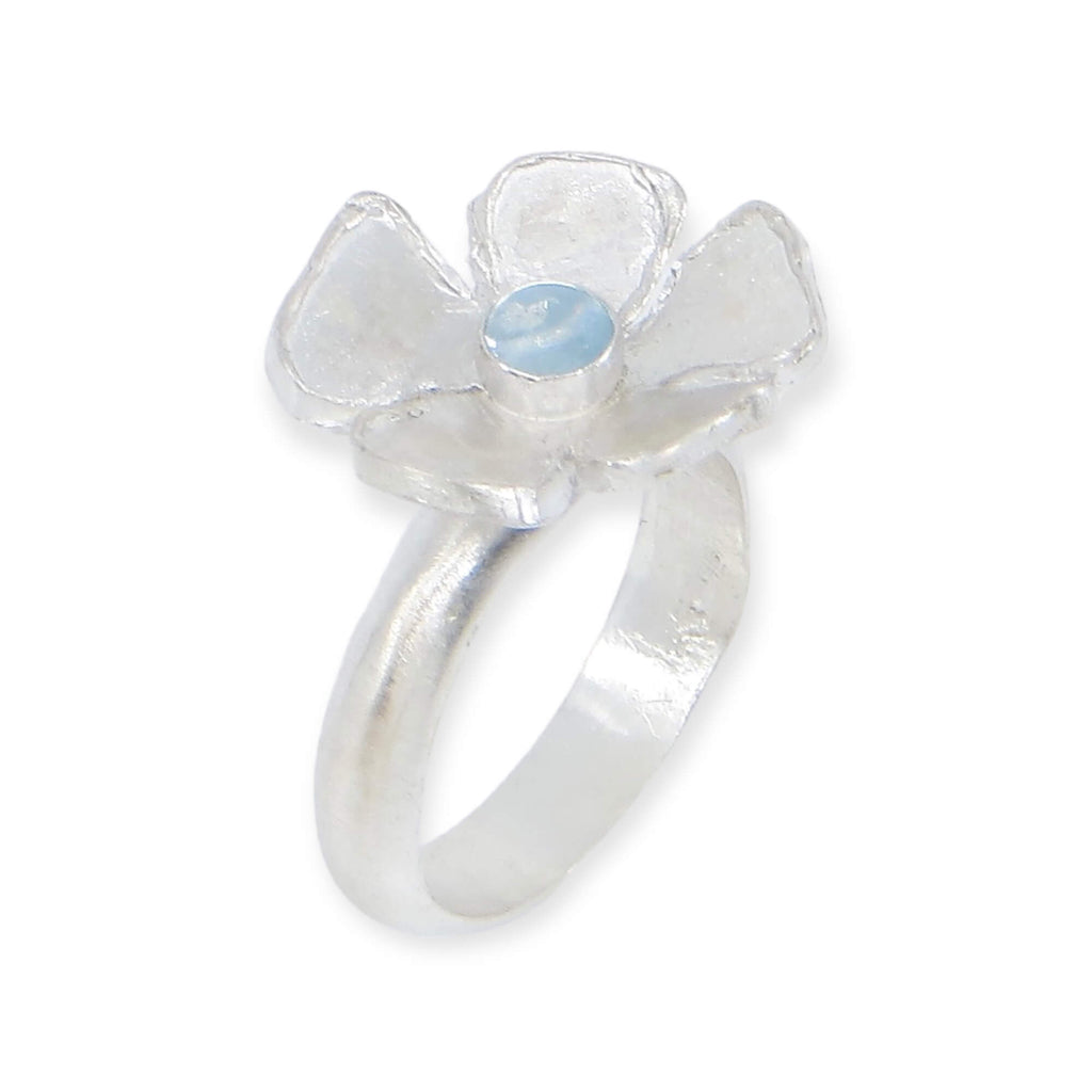 Big single flower ring with center sky blue topaz cabochon. Satin finish sterling silver. Modern elegance. US Size 5.5