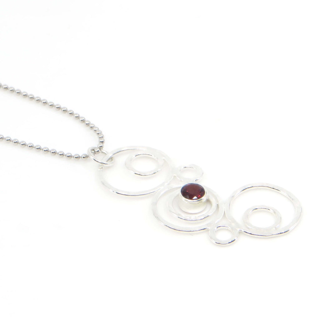 Hammered argentium silver circles-bubbles-of different sizes pendant with 4mm tube set garnet. Bubblescence necklace. Sterling bead chain.
