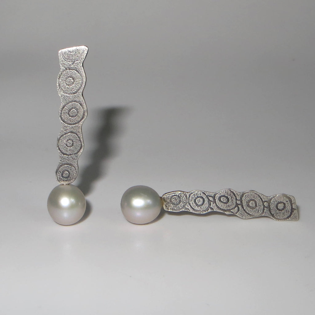 Lustrous grey pearls are suspended from an etched flat piece of long silver. Post earrings with circle patterns.  OOAK pearl earrings.