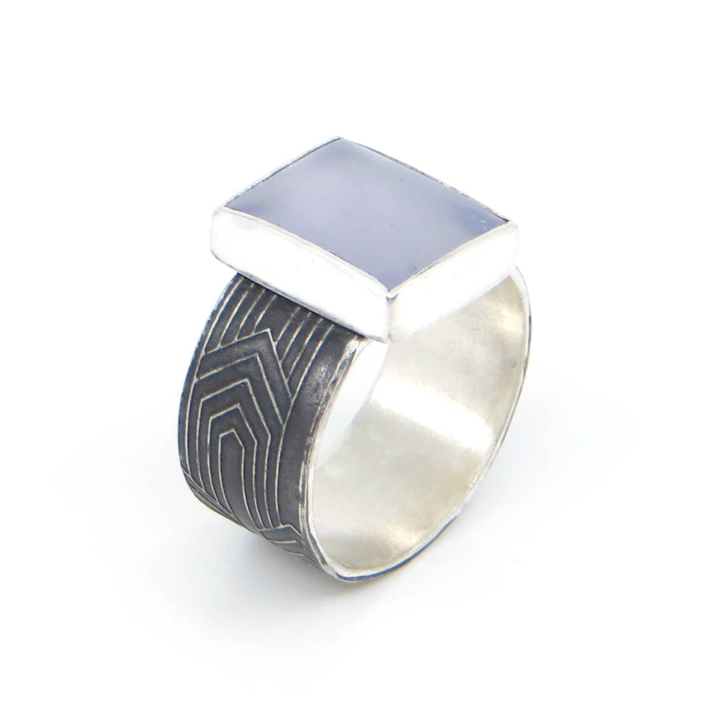 Rectangular lustrous periwinkle blue chalcedony set on sterling silver and black patina art deco pattern ring band.  US Size 6.75