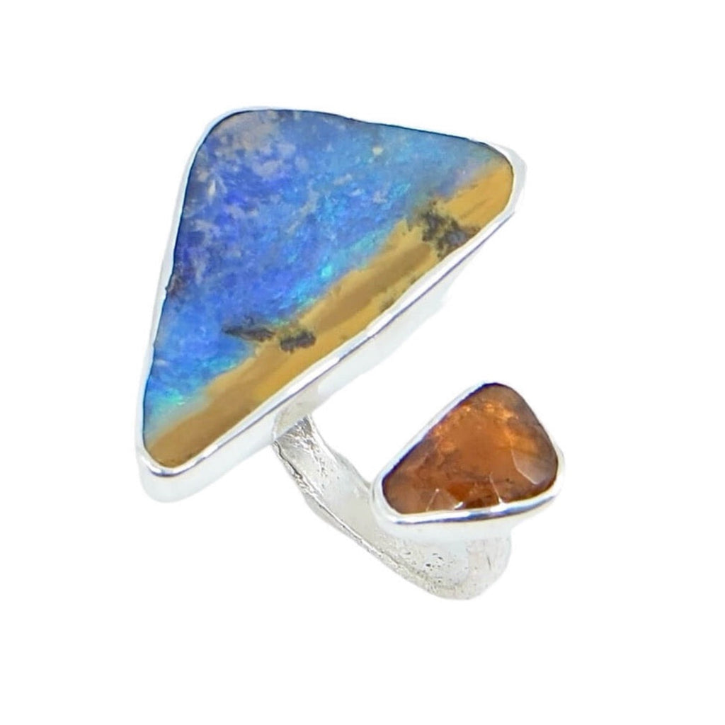 Open top ring. Big triangular blue and maize boulder opal with smaller rose cut triangular hessonite garnet. Sand cast sterling silver band. Fits US sizes 5.5-6.5. Looks like the colors of a beach and a golden sunset.