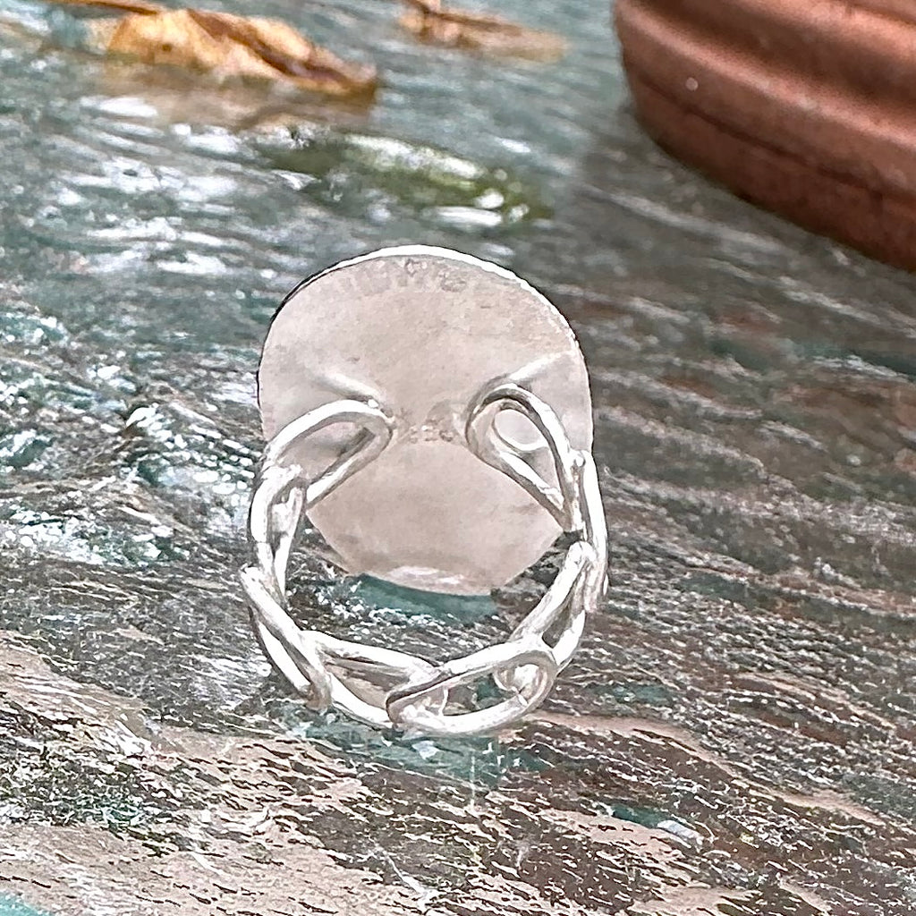 Back of ring showing band attached. Sitting on table just rained to show off the silver.