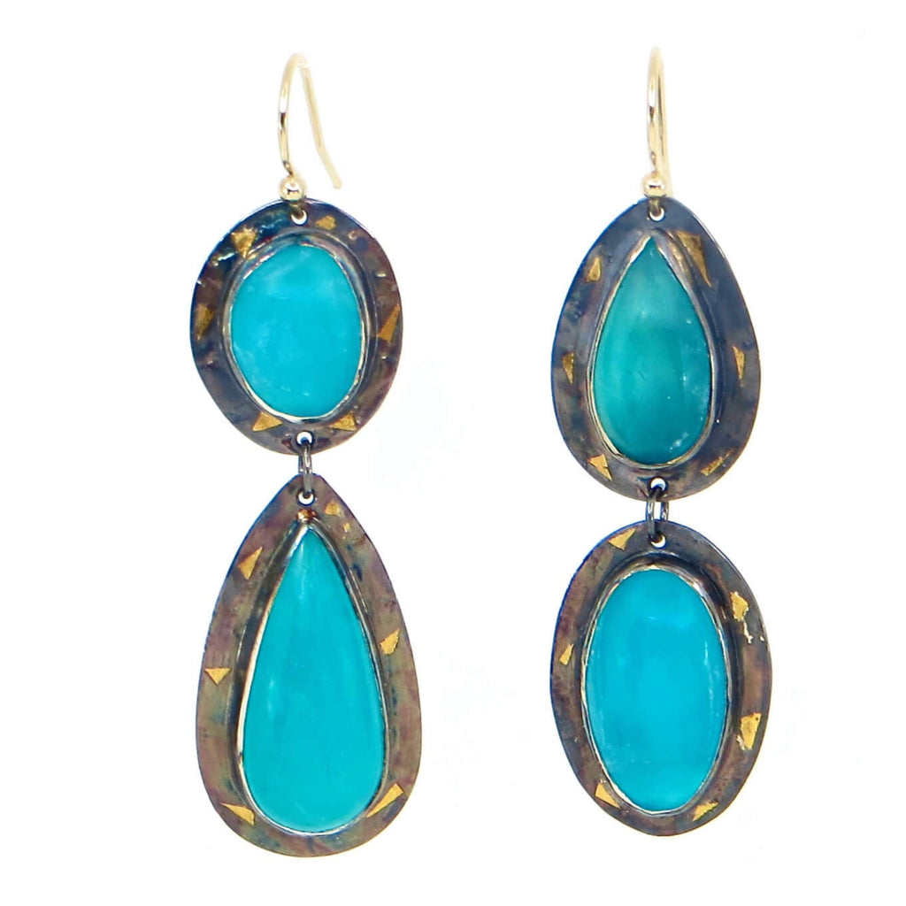 Oval and pear shaped cabochon amazonites of vivid turquoise blue earrings. Oval dangles a pear and pear dangles an oval for opposite placed components. Bezel set stones on sterling silver backings with pieces of 24k gold arranged around the settings. A black patina provides the perfect contrast. Dangle earrings. 2.25"