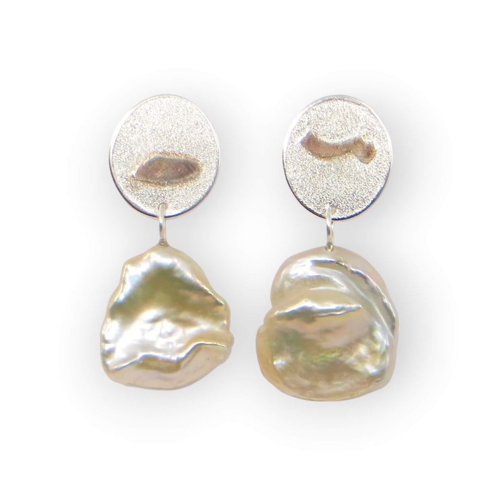 Champagne lustre keshi pearls with unique dimensional pattern post earrings. Texture oval sterling post components have matching on opposite earrings embossed patterns of the pearls with rose gold added to accentuate the design. Subtle elegance.