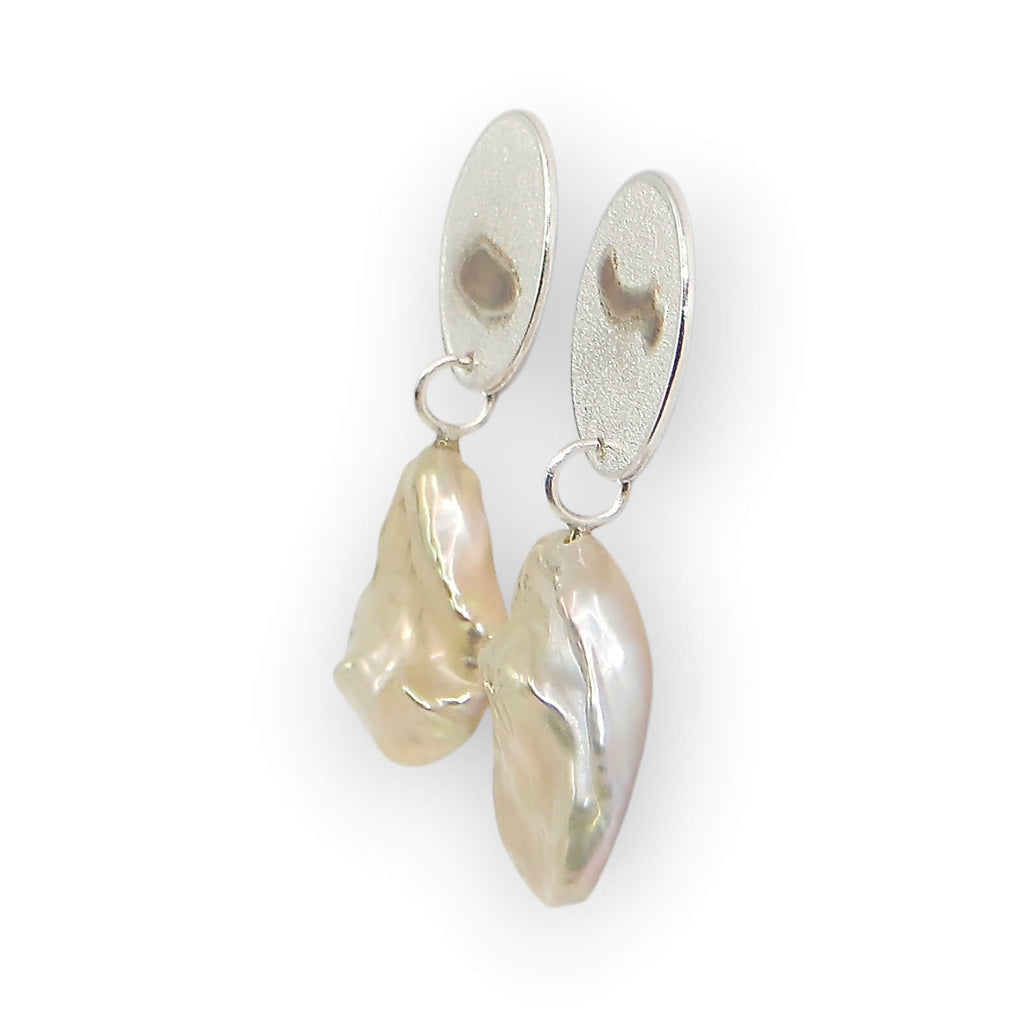 Champagne lustre keshi pearls with unique dimensional pattern post earrings. Texture oval sterling post components have matching on opposite earrings embossed patterns of the pearls with rose gold added to accentuate the design. Subtle elegance.