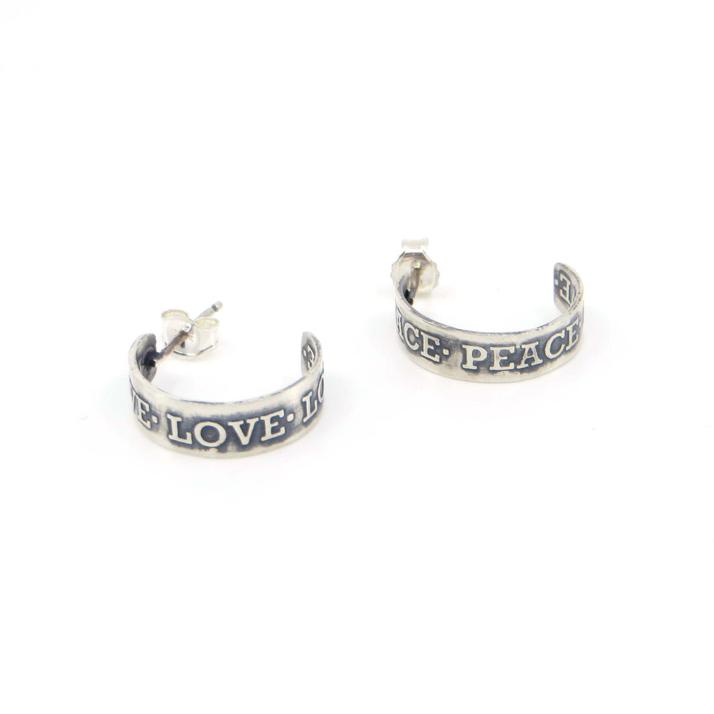 Peace and Love post  3/4 hoop earrings. Etched with raised lettering on inside and outside of the sterling silver hoops. Earrings are opposites. Black patina in recesses to highlight the words.