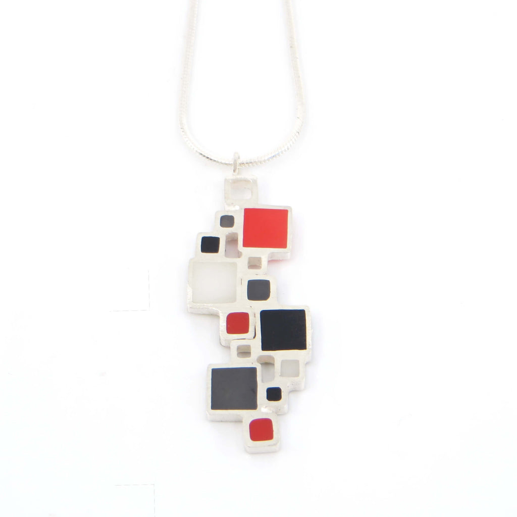 Colorful geometric pendant necklace on a white background. Sterling silver squares, some open, some filled with color.
