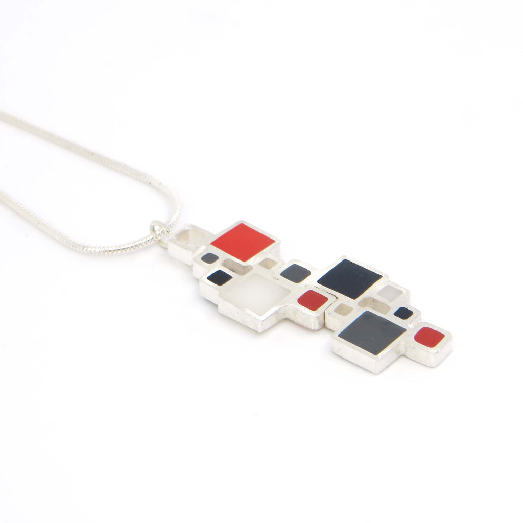 Colorful geometric pendant necklace on a white background. Sterling silver squares, some open, some filled with color.