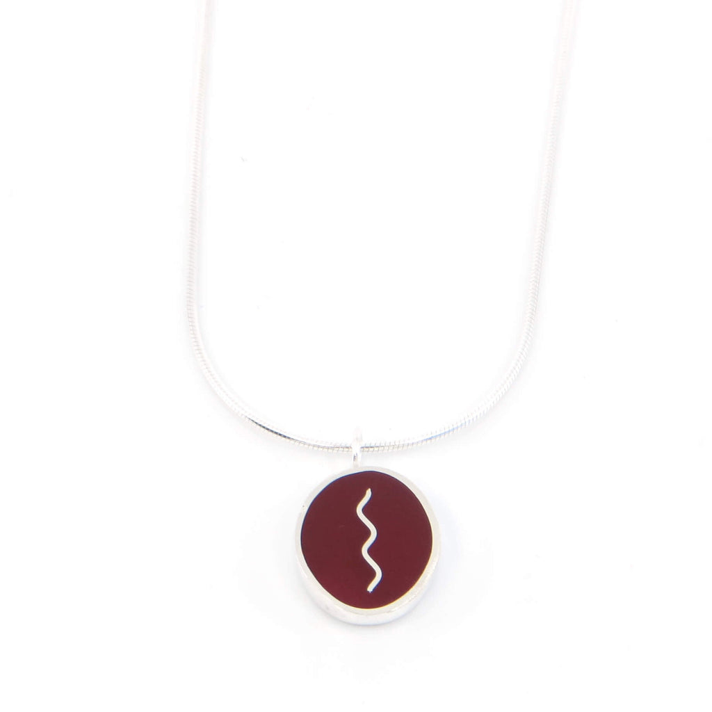 Sterling silver oval pendant with vertical center squiggle. Maroon.