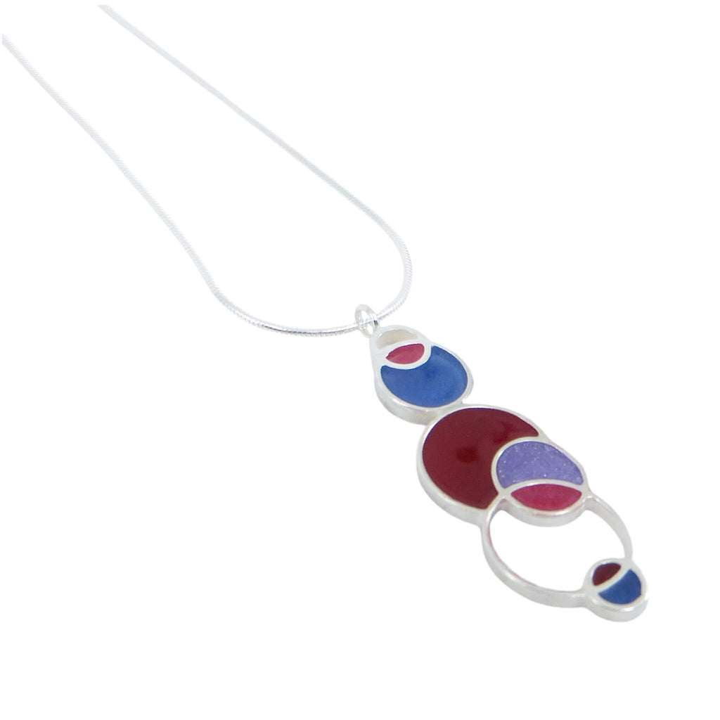 Open circles pendant. Sterling silver and pigmented resin. Sterling 16" snake chain. Maroon, violet blue, fuchsia, and lavender. Matte finish one side, shiny other side.