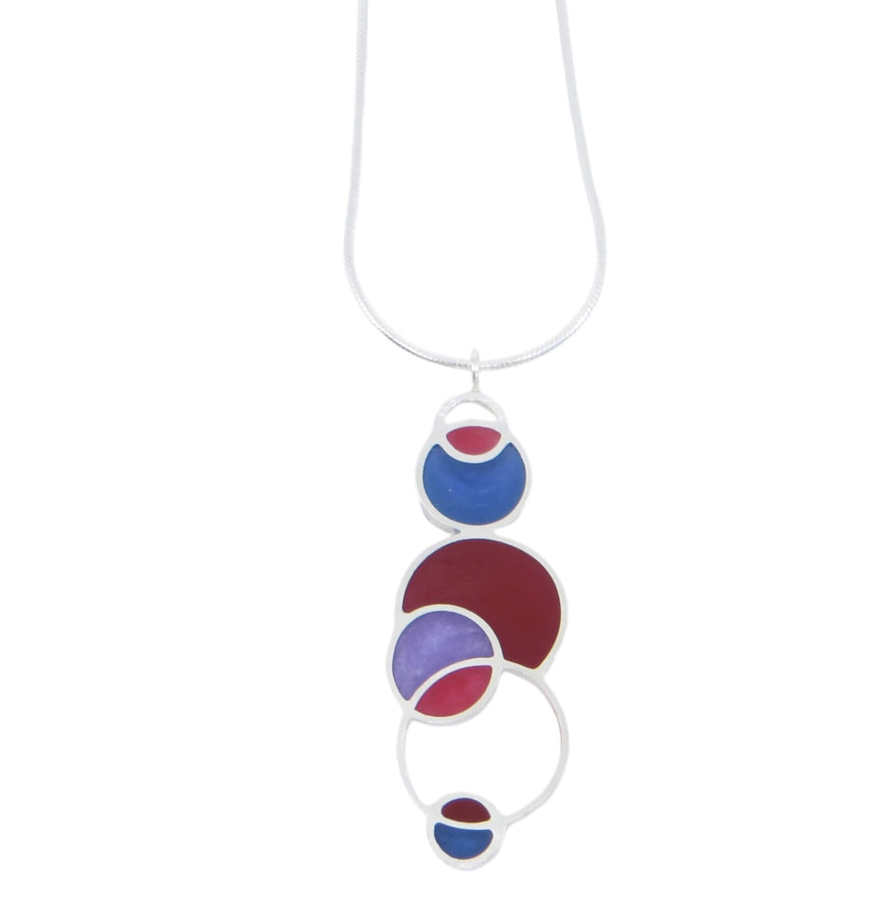 Open circles pendant. Sterling silver and pigmented resin. Sterling 16" snake chain. Maroon, violet blue, fuchsia, and lavender. Matte finish one side, shiny other side.