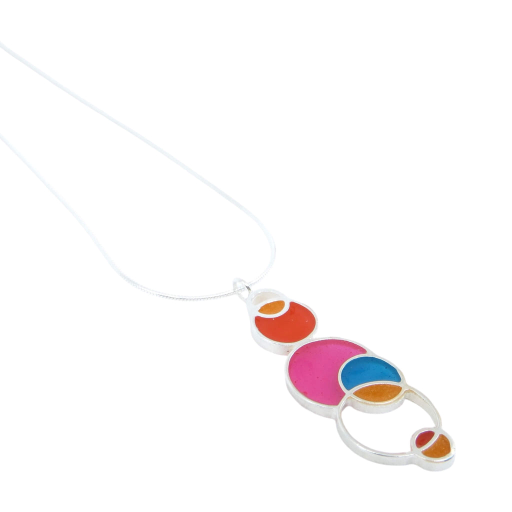 Open circles pendant. Sterling silver and pigmented resin. Sterling 16" snake chain. Pink, dark orange, orange, aqua. Matte finish one side, shiny other side.