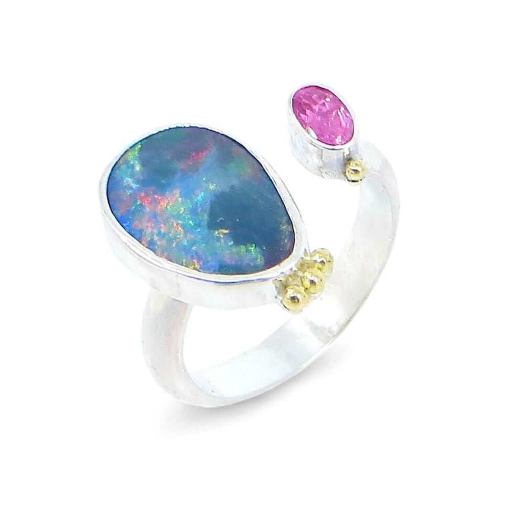 Open top boulder opal and pink oval faced tourmaline ring. 3 18k royal yellow gold balls at top of opal setting. 1 18k royal yellow gold ball on top of tourmaline setting. Crown look. Sterling silver 1/2 round band. Bezel set stones. US size 6.25 adjustable up or down a quarter size.