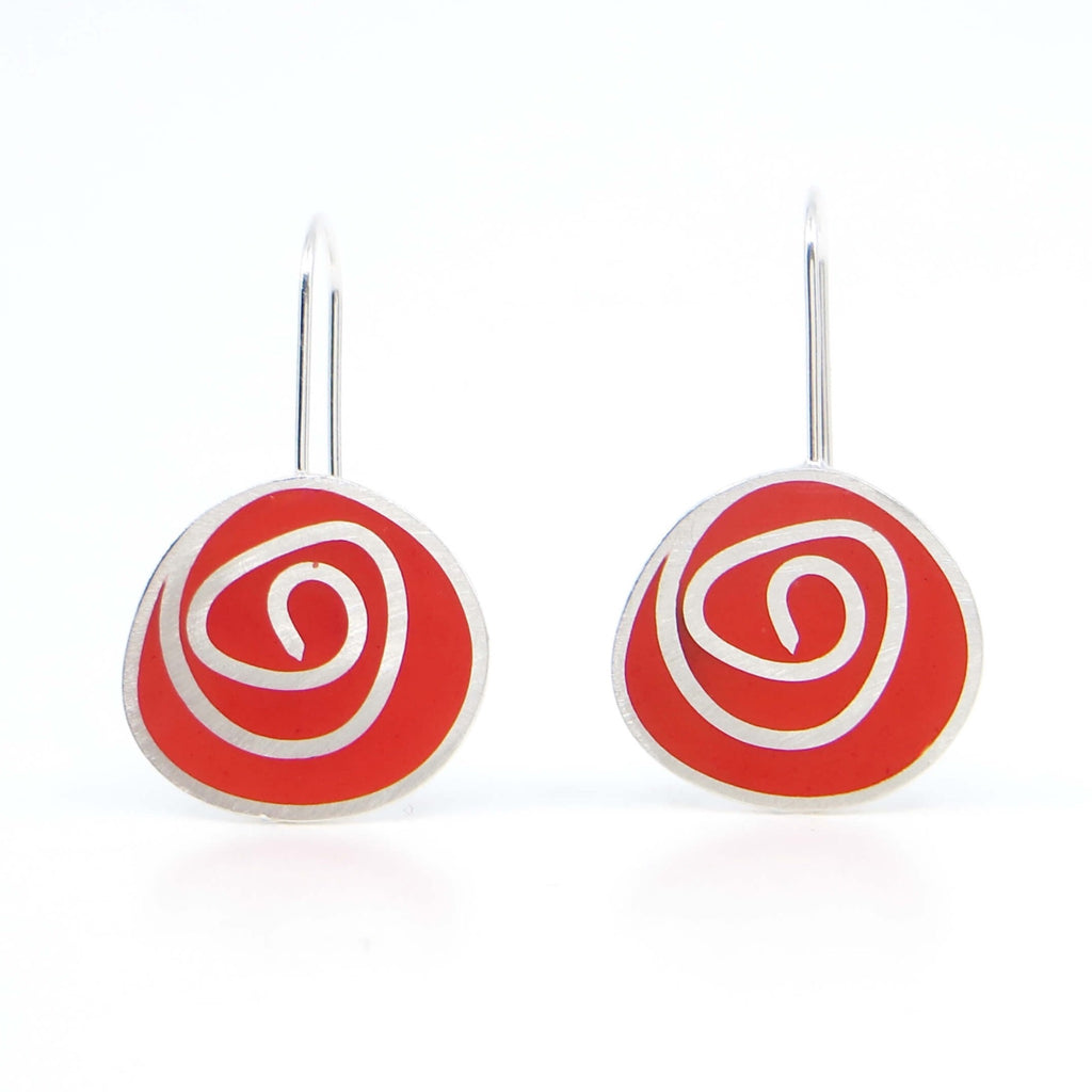 Sterling silver dangle earrings with swirl pattern.  Resin pigmented with red chalk pastel fills the receptacles between the swirl pattern and is sanded down flush with the silver.