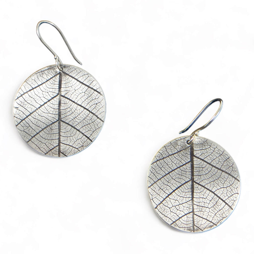 Leaves!  These round silver dangle earrings have indented impressions of a real leaf.  No other pair will have this exact leaf design. A black patina in the recesses highlight the delicate veins which happen to resemble a peace sign--with some addition lines!  These are curved ever so slightly that they hand perfectly from the ear lobe.  Sterling Silver 1" diameter disc. Peace! 