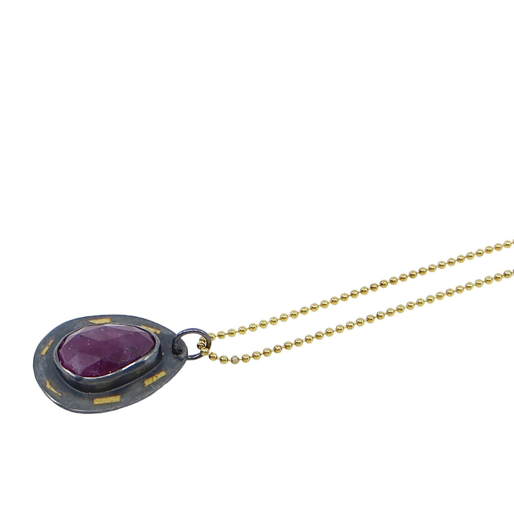 Pear shape rose cut ruby set on kaum-boo pear shaped border. 24k gold pieces on black patinated sterling. 16" gold bead chain.