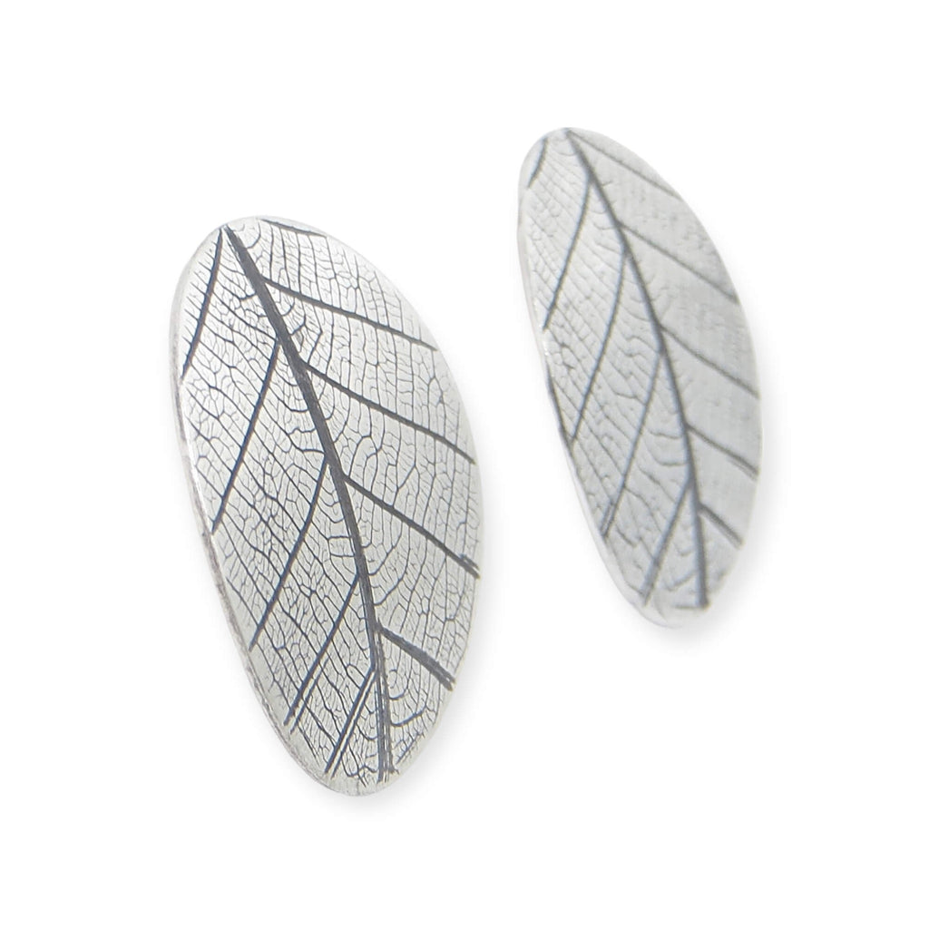 Leaf textured 1" round post silver earrings with black patina in the vein recesses. The leaf impression resembles a peace sign.