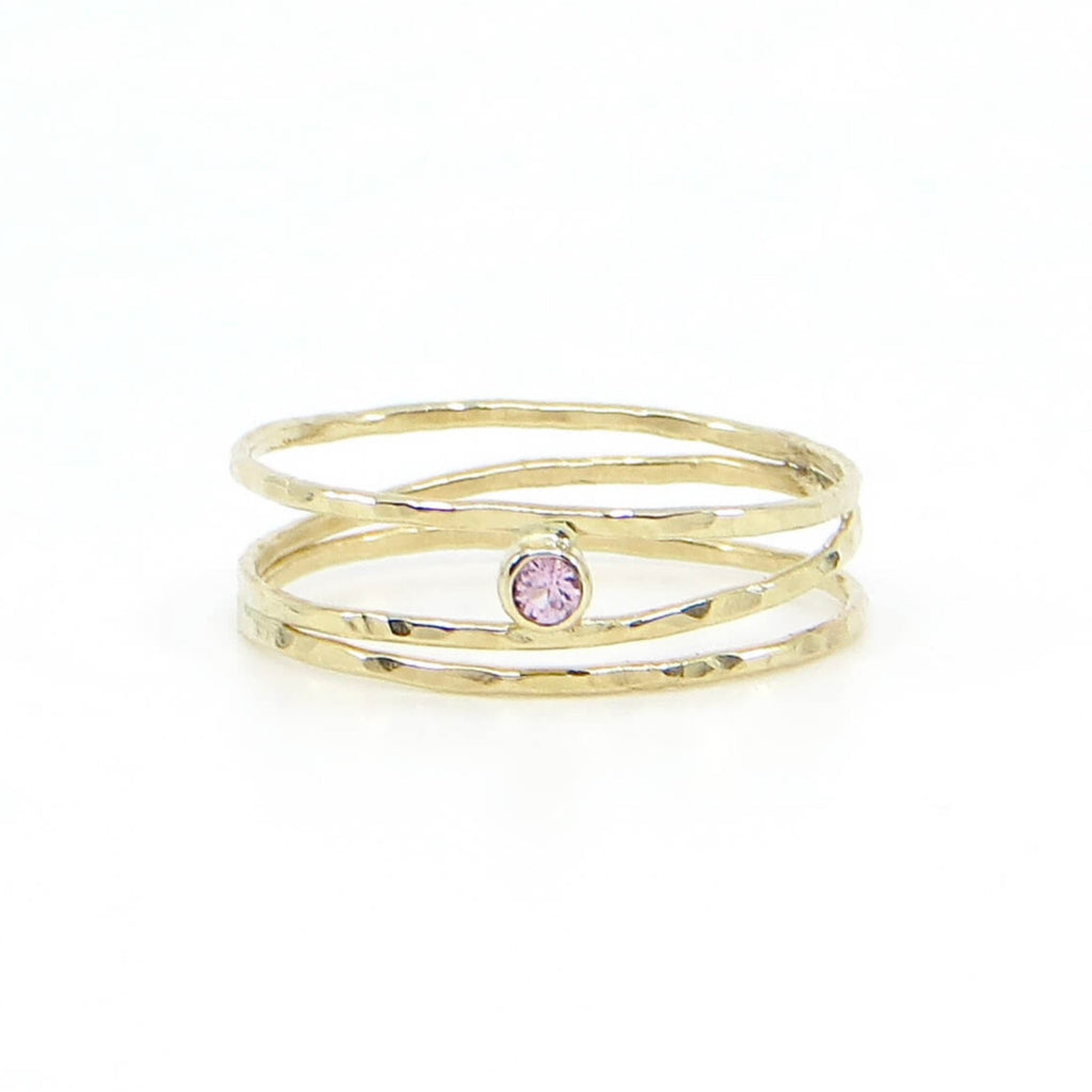 3 hammered 14k gold bands are attached at different points that make it look like an airy set of stacking rings. A tube set lavender garnet is hugged between to of the bands to add a lovely pink lavender sparkle. US size 7.