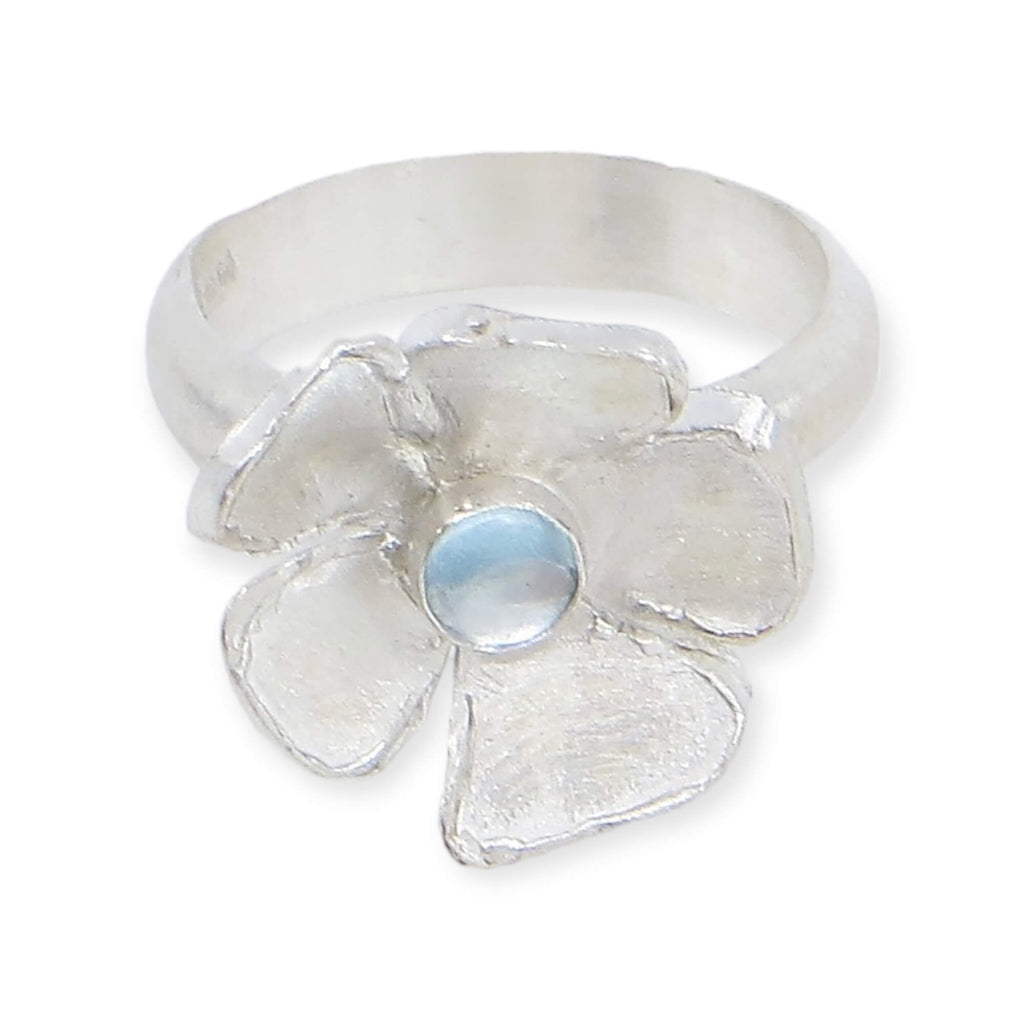 Big single flower ring with center sky blue topaz cabochon. Satin finish sterling silver. Modern elegance. US Size 5.5