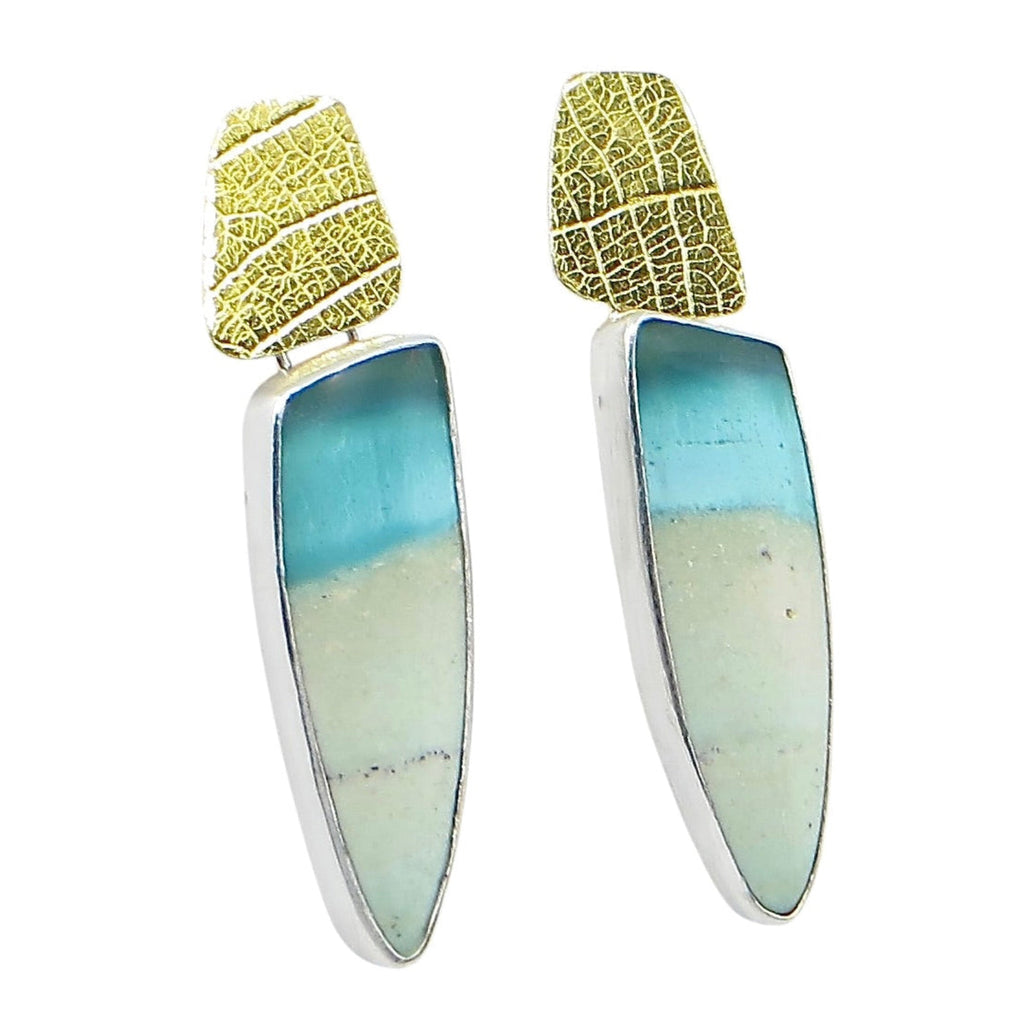 Earrings. Turquoise and beige colored stones that are opalized petrified wood suspended from leaf imprinted 24k gold over silver components.