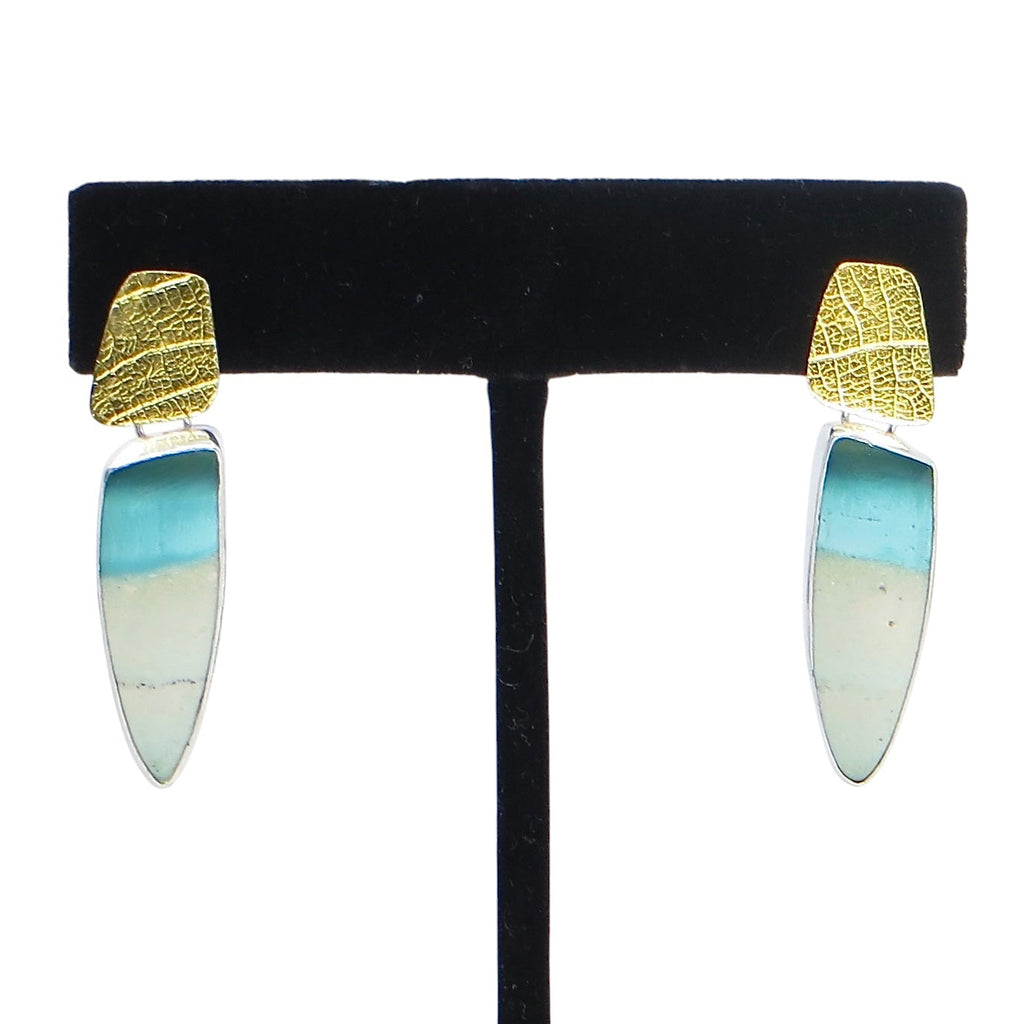 Earrings. Turquoise and beige colored stones that are opalized petrified wood suspended from leaf imprinted 24k gold over silver components.