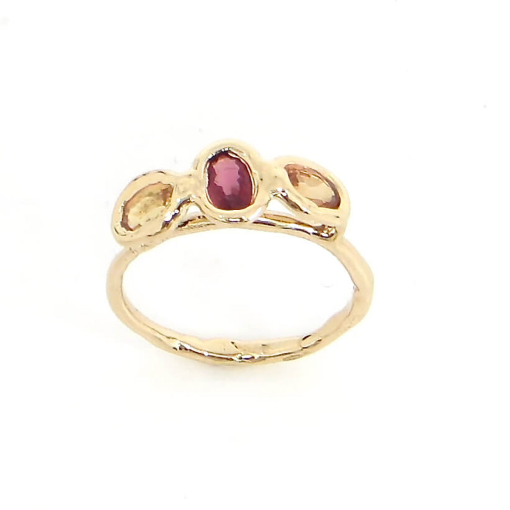 Gold and 3 oval sapphire ring. Peach side sapphires and center dark red sapphire. Organic feel shaped gold ring band and settings. Sapphires float above ring band. US size 5.5