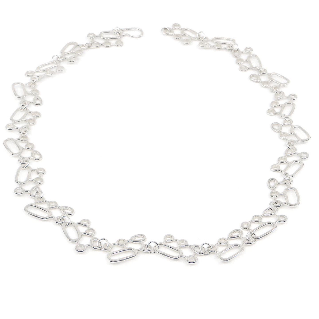 Organic geometric components of circles and ovals are linked together to make a slightly kinetic chain that dances on the neck. Sort of molecular in design. Sterling silver.