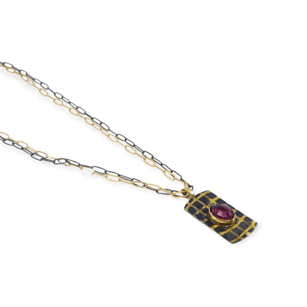 Gold and black grid pendant with rose cut oval garnet. 18k royal yellow gold bail, 18k gold grid, 14k gold bezel. Gold and black chains.
