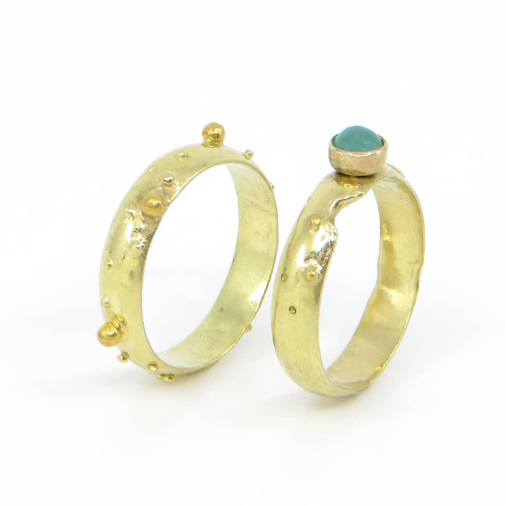 18k yellow gold ring set. Various sized gold balls scattered around bands. One band has a 14k set green chrysoprase. Contemporary granulation.