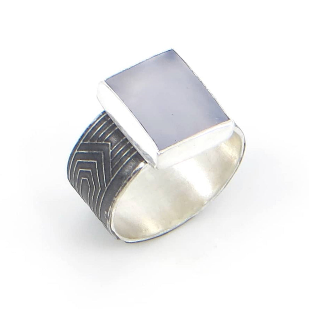 Rectangular lustrous periwinkle blue chalcedony set on sterling silver and black patina art deco pattern ring band.  US Size 6.75