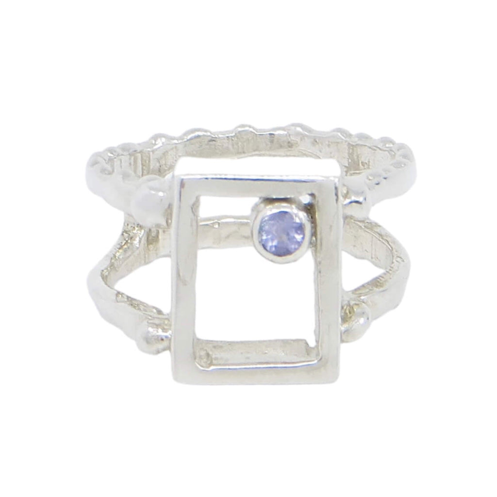 Sterling silver and tanzanite ring. US size 5.5. Open rectangle with tube set tanzanite in one inner corner. 2 band ring band with bead bumps on front and back of both bands.